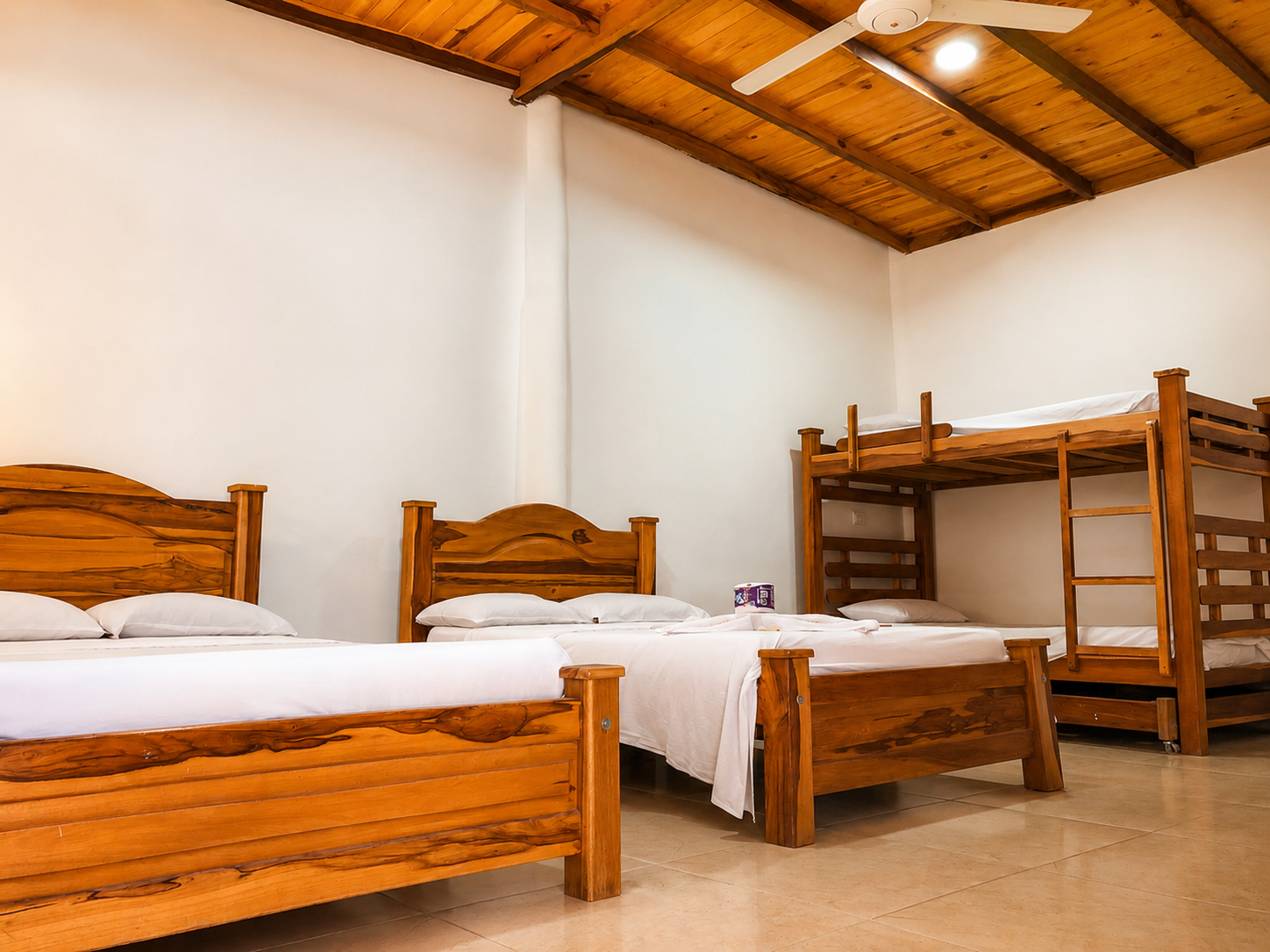 Habitación acogedora del Hotel Zona Tropical con camas de madera, techos rústicos y ambiente tropical